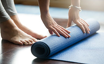 Woman rolling up yoga mat