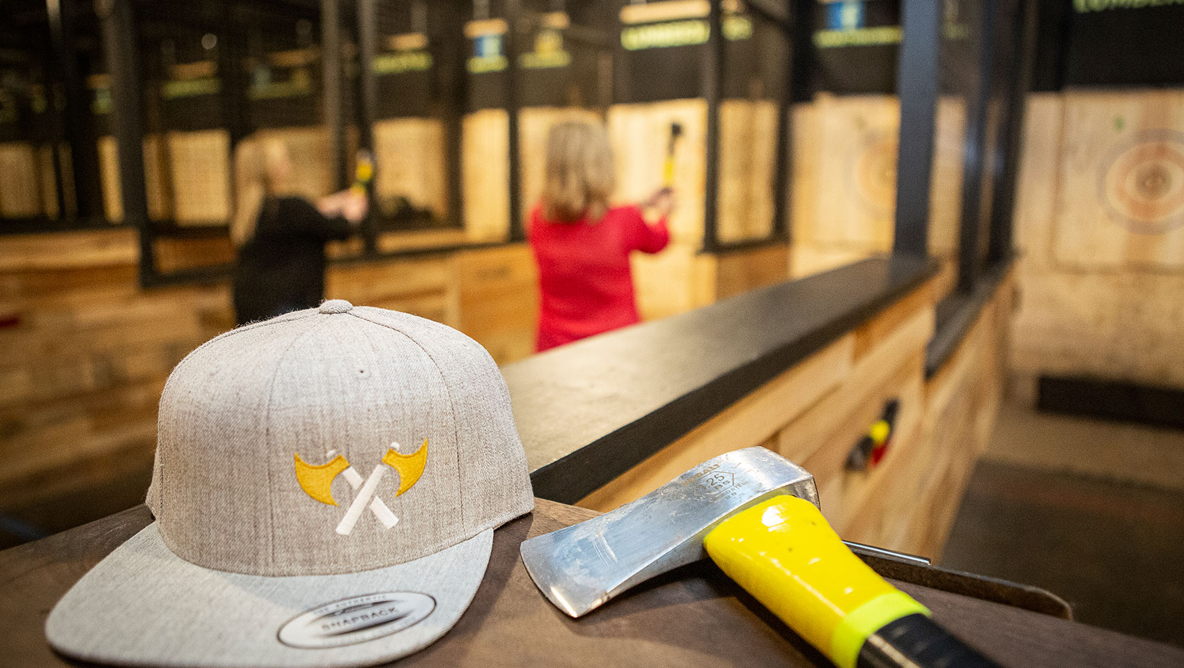 Axe throwing range with gray hat and axe 