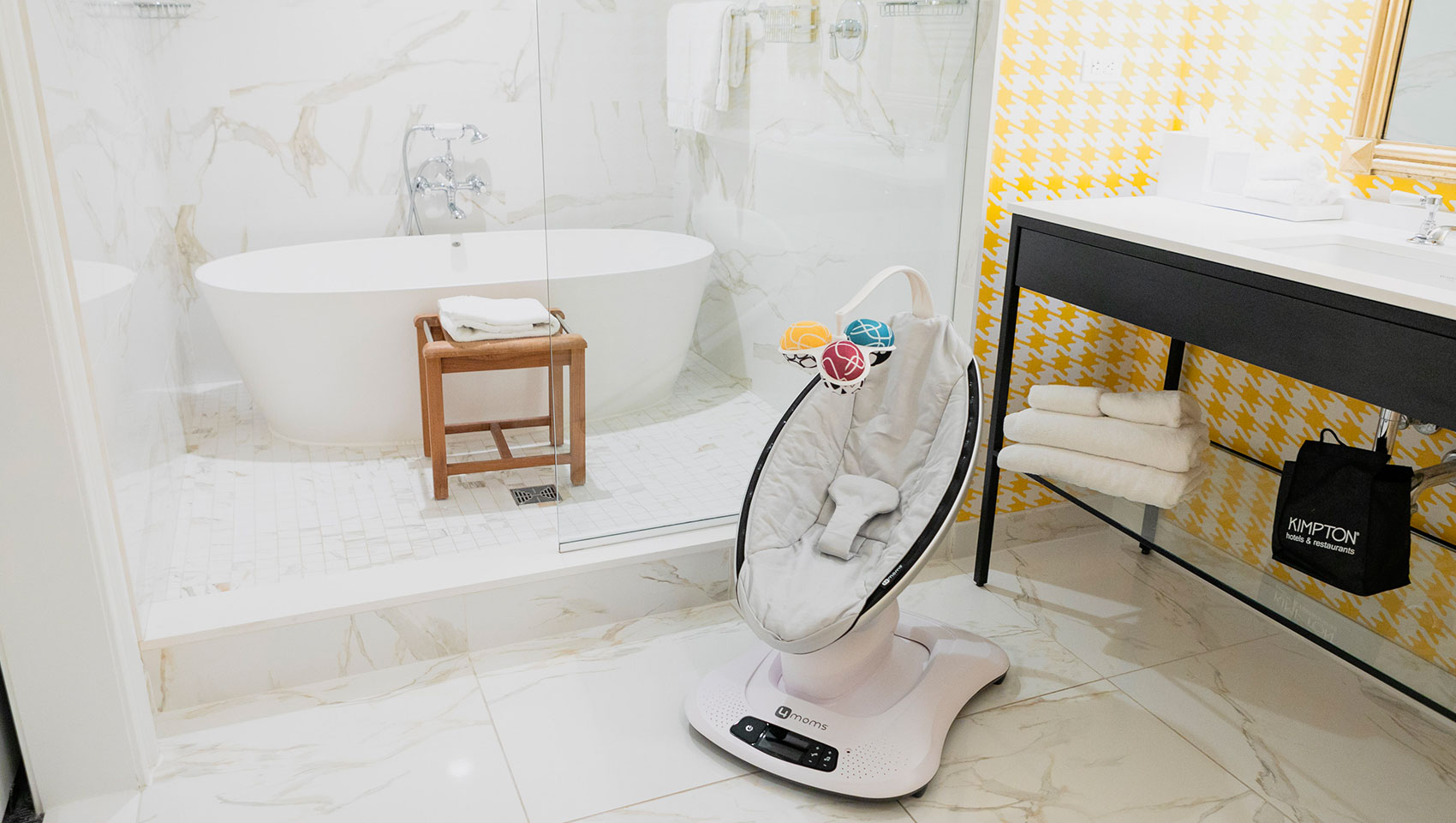 4moms rocking infant seat in Kimpton Hotel Monaco Pittsburgh’s bathroom next to large stand in shower with a tub also