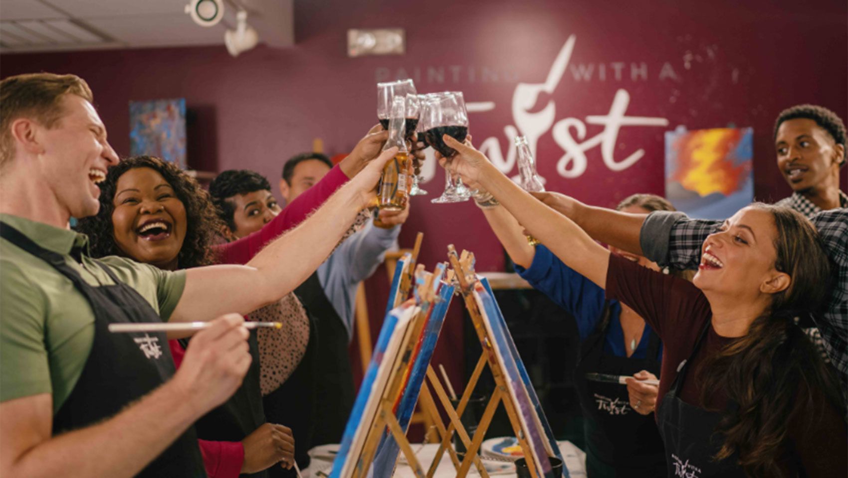 people cheersing wine at a paint and sip class