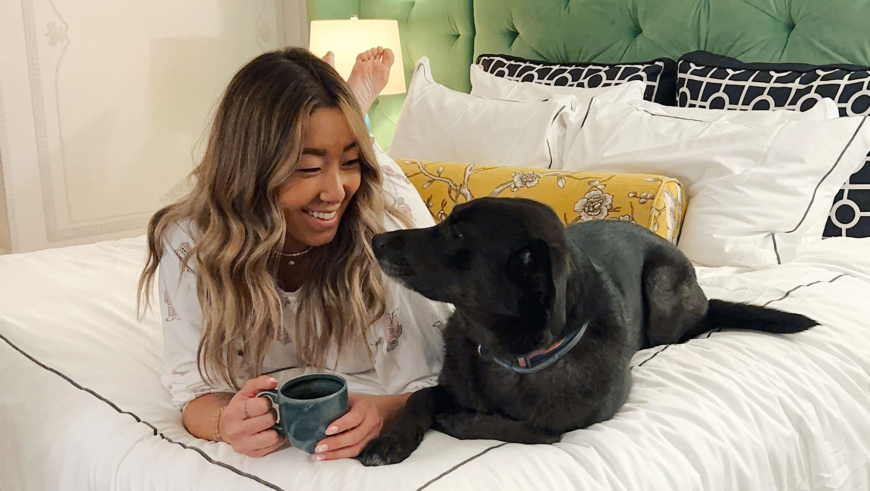 image of woman and dog looking at each other on bed