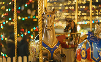 Carousel horse in front of holiday lights